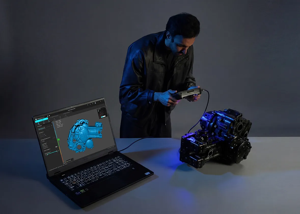 Homem escaneando um motor com o scanner ligado a um notebook