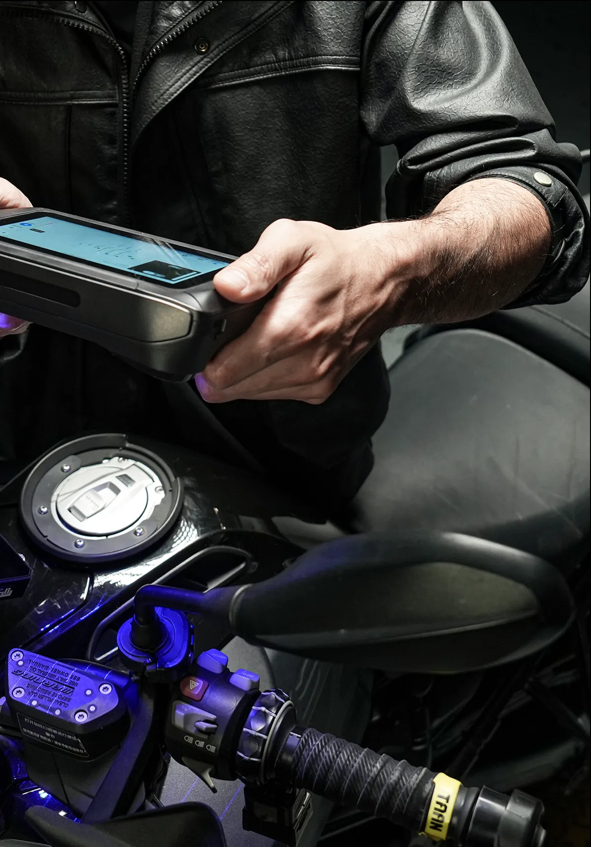 Mãos escaneando uma peça de moto com laser azul